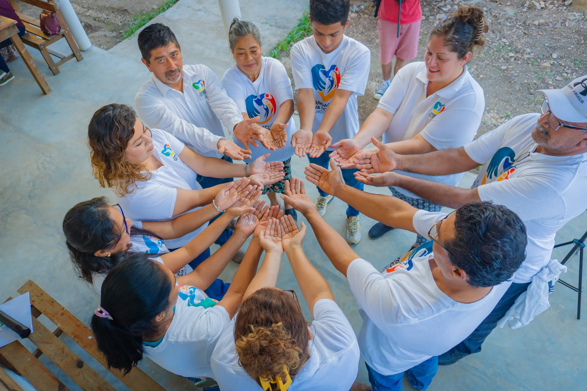 Volunteers in a circle joining hands together outdoors