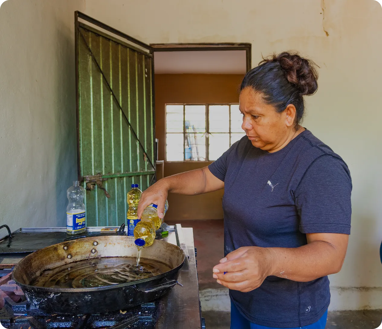 A woman smiling warmly while shelling corn outdoors