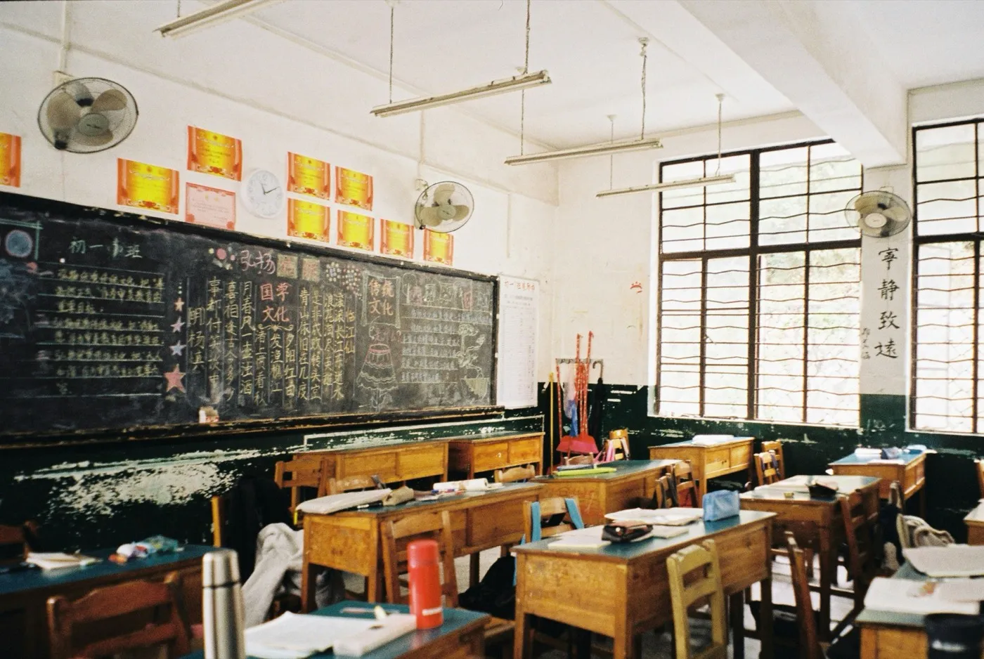 A bright classroom with wooden desks and chairs